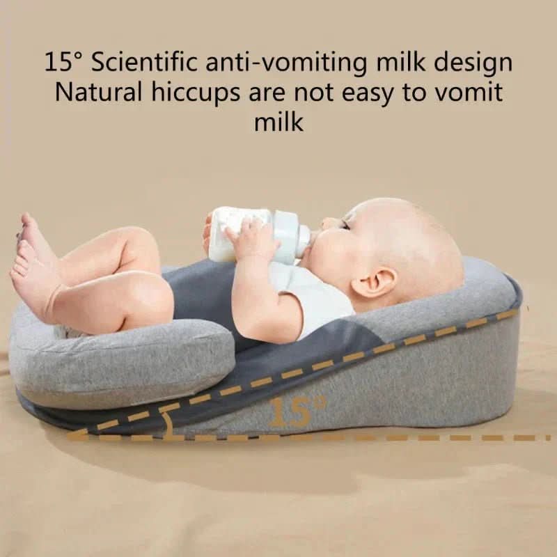 Baby der ligger på den ergonomiske pude i vuggen