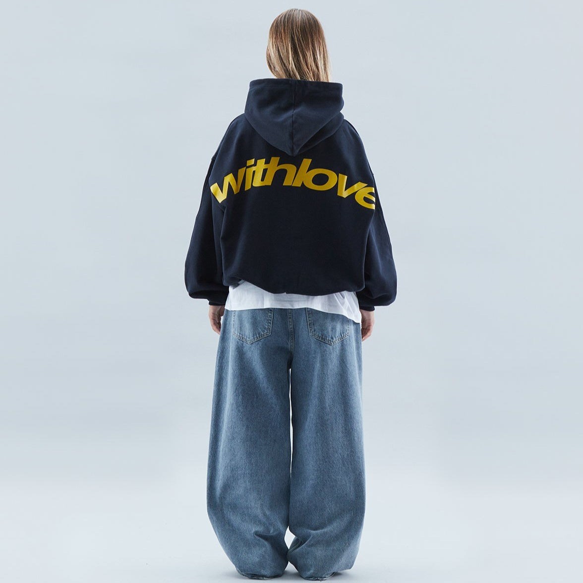 Dame i grå oversize hoodie med tryk på ryggen