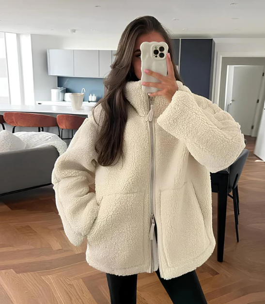 Dame i beige teddyjakke med lynlås og høj hals