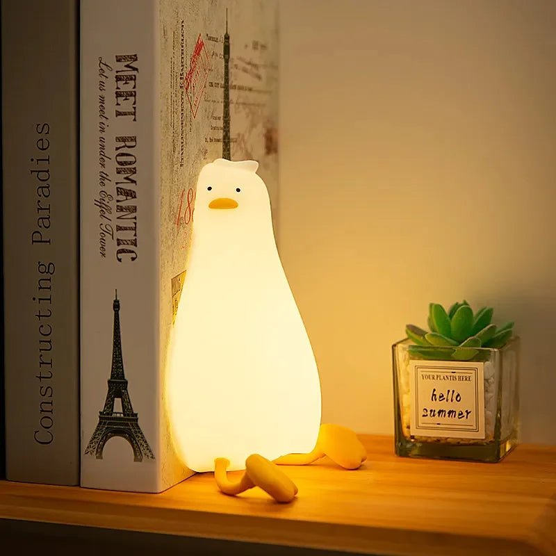 Barnehånd der holder en lille silikonenatlampe formet som en kanin