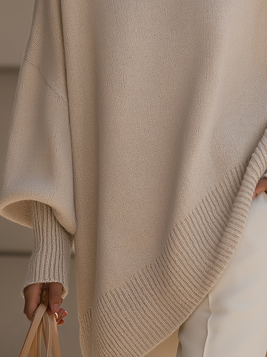 Beige strikket dametrøje med ribkant og vidt ærme, set tæt på ved hoften