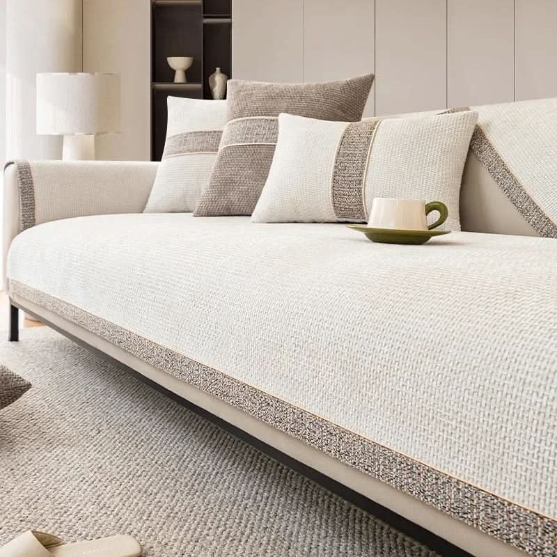 SOFAVÆRN skridsikkert sofaovertræk i beige lagt over en sofa